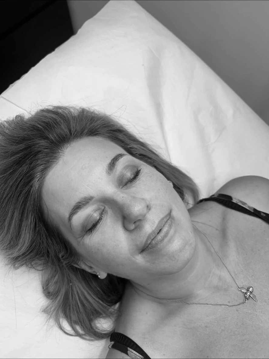 Client resting on the treatment bed after a brow treatment